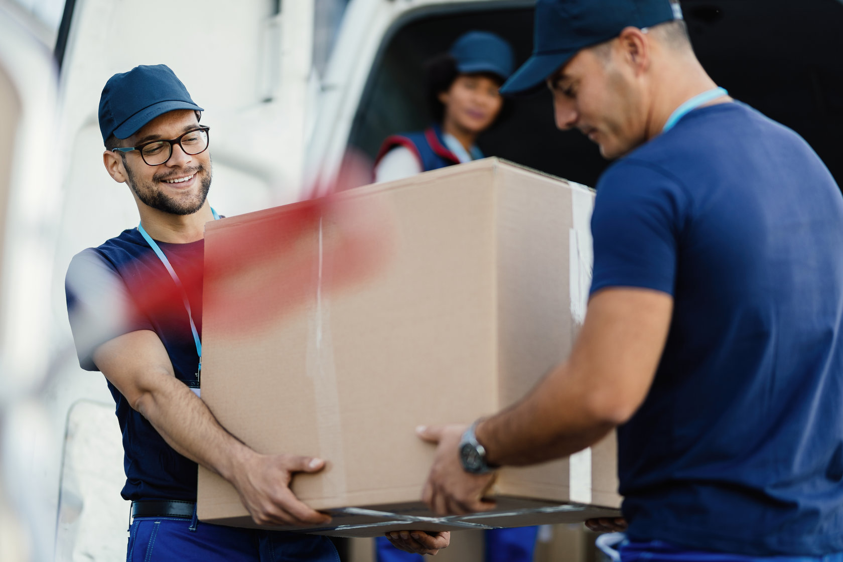 two people carrying a box